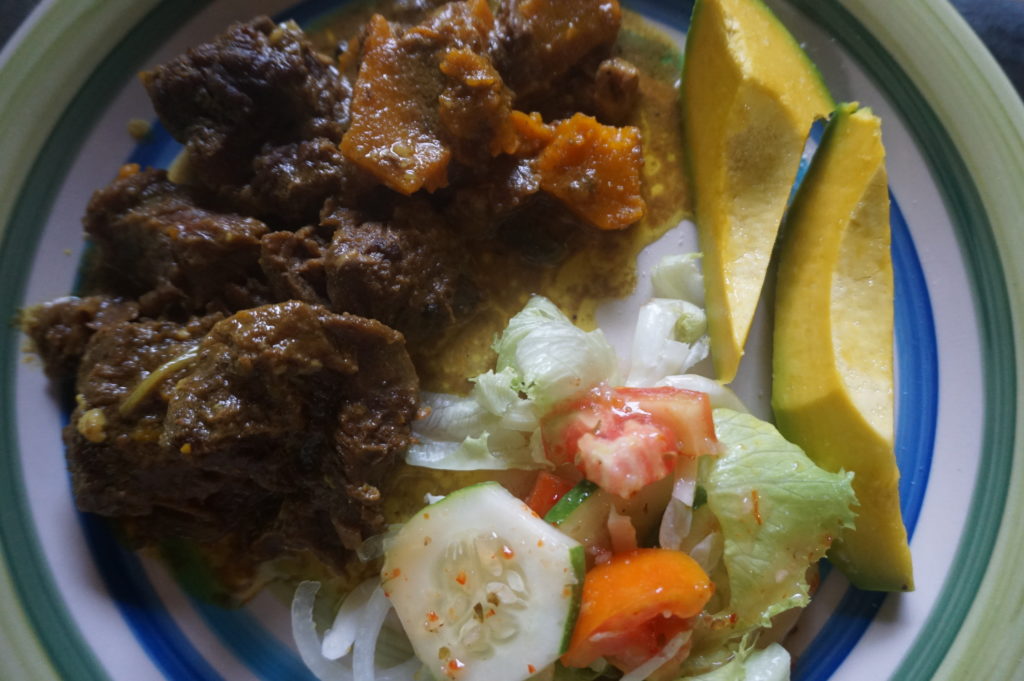 Keto dinner: curried beef with pumpkin, ripe avocado, garden salad