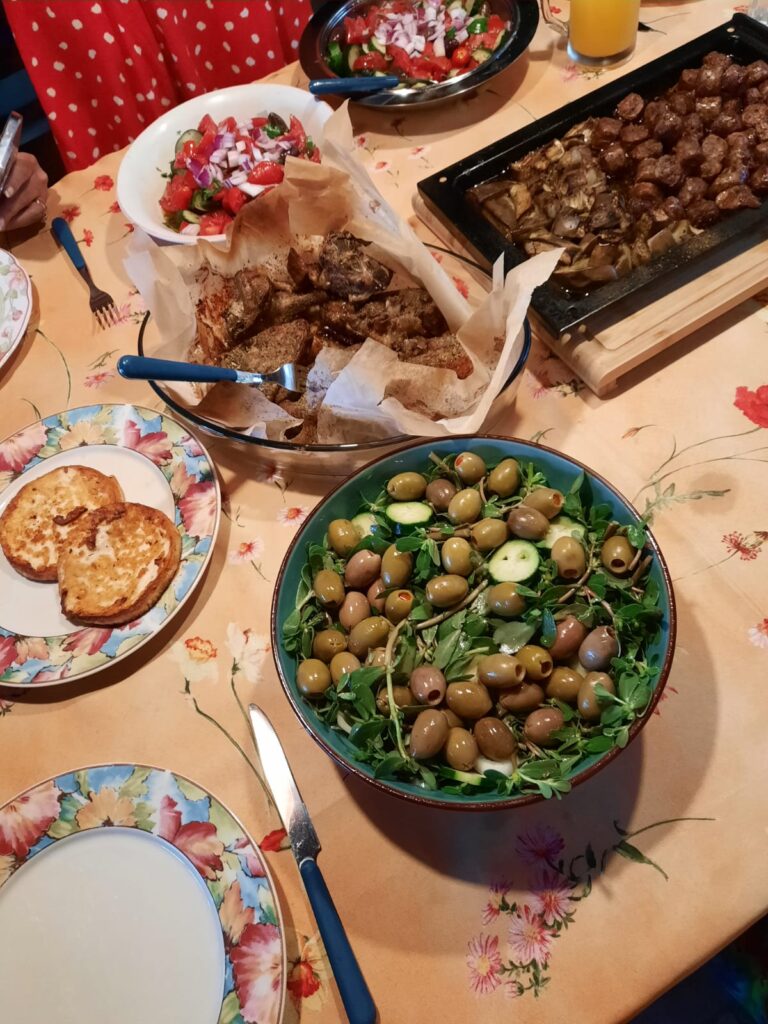 A spread at home cooked by Roberta and Us! Lamb chops, mutton sausage, salads, fried cheese.